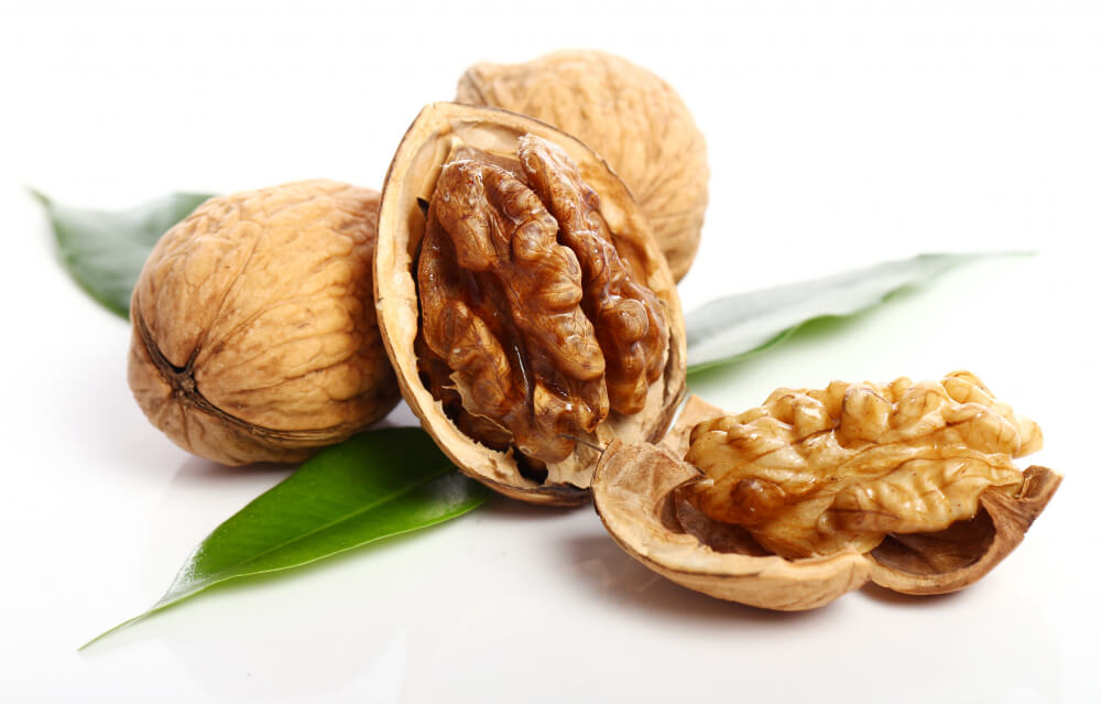 Whole and shelled walnuts rich in antioxidants and omega-3s, known to brighten skin and improve overall skin tone.